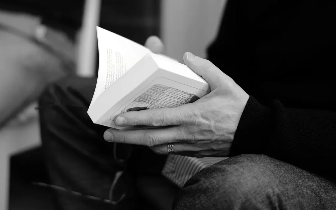 Une personne lit un livre en noir et blanc.